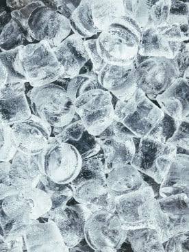 Ice cubes in a close-up shot, glistening and transparent.